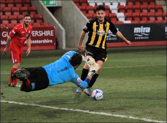 Goalkeeper Dan Crane dives at the feet of City striker Connor Waldon